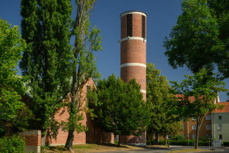 Die Dreieinigkeitskirche mit ihrem markanten runden Turm inmitten von Bäumen